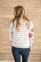 Model showing back view of floral sweatshirt.